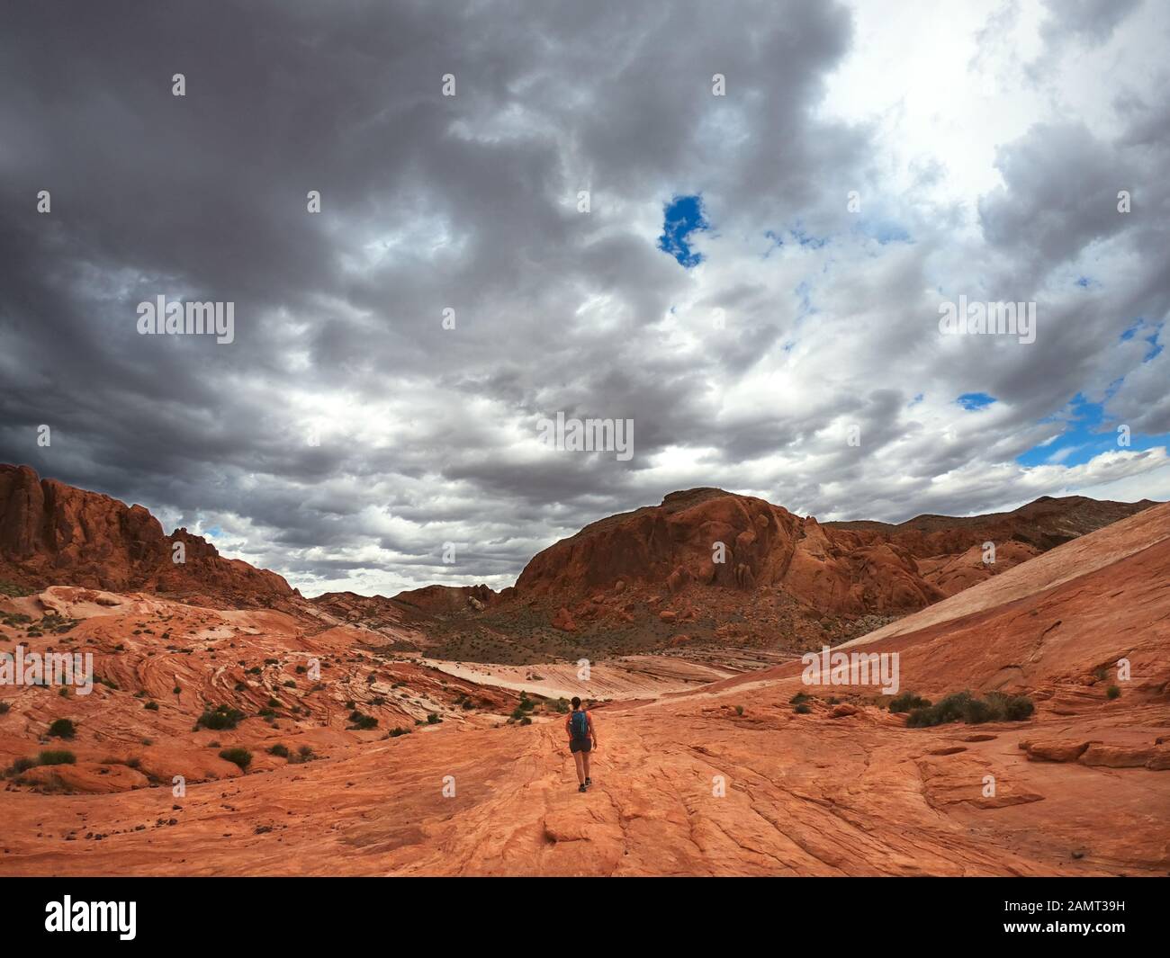 Frau, die im Valley of Fire State Park mit Sturmflut naht, Nevada, USA, wandert Stockfoto