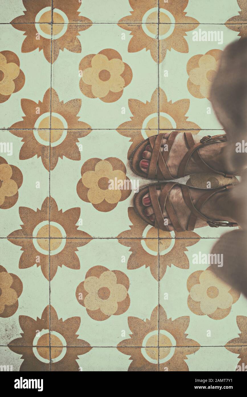 Die Füße der Frau stehen auf einem gefliesten Boden Stockfoto