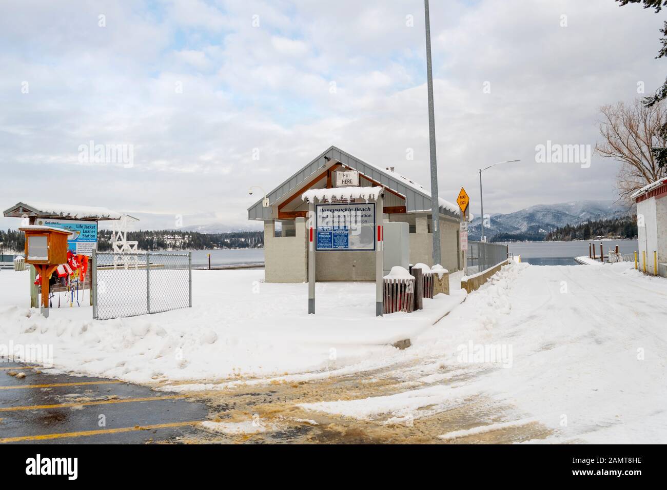 Das öffentliche Änderungshaus, die Rettungsweste und der Bootsanlegeplatz am Honeysuckle Beach, Hayden Lake, Idaho USA, wo viele Winterausrutschen im See zu sehen sind. Stockfoto
