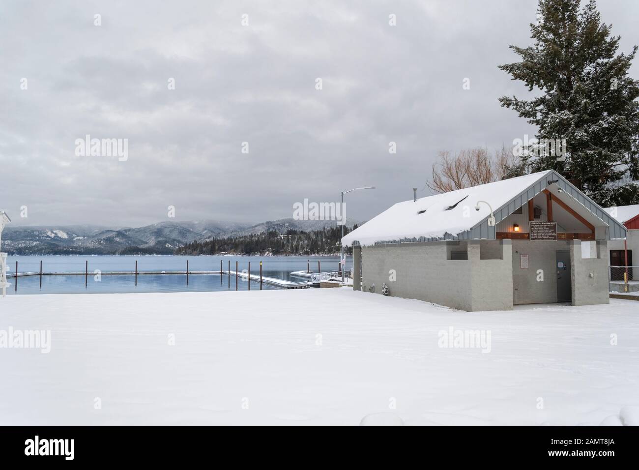 Die Toilette, der Schwimmbereich, das Dock und das öffentliche Wechselhaus am Honeysuckle Beach im Winter in der Bergresortstadt Hayden Lake, Idaho, USA. Stockfoto