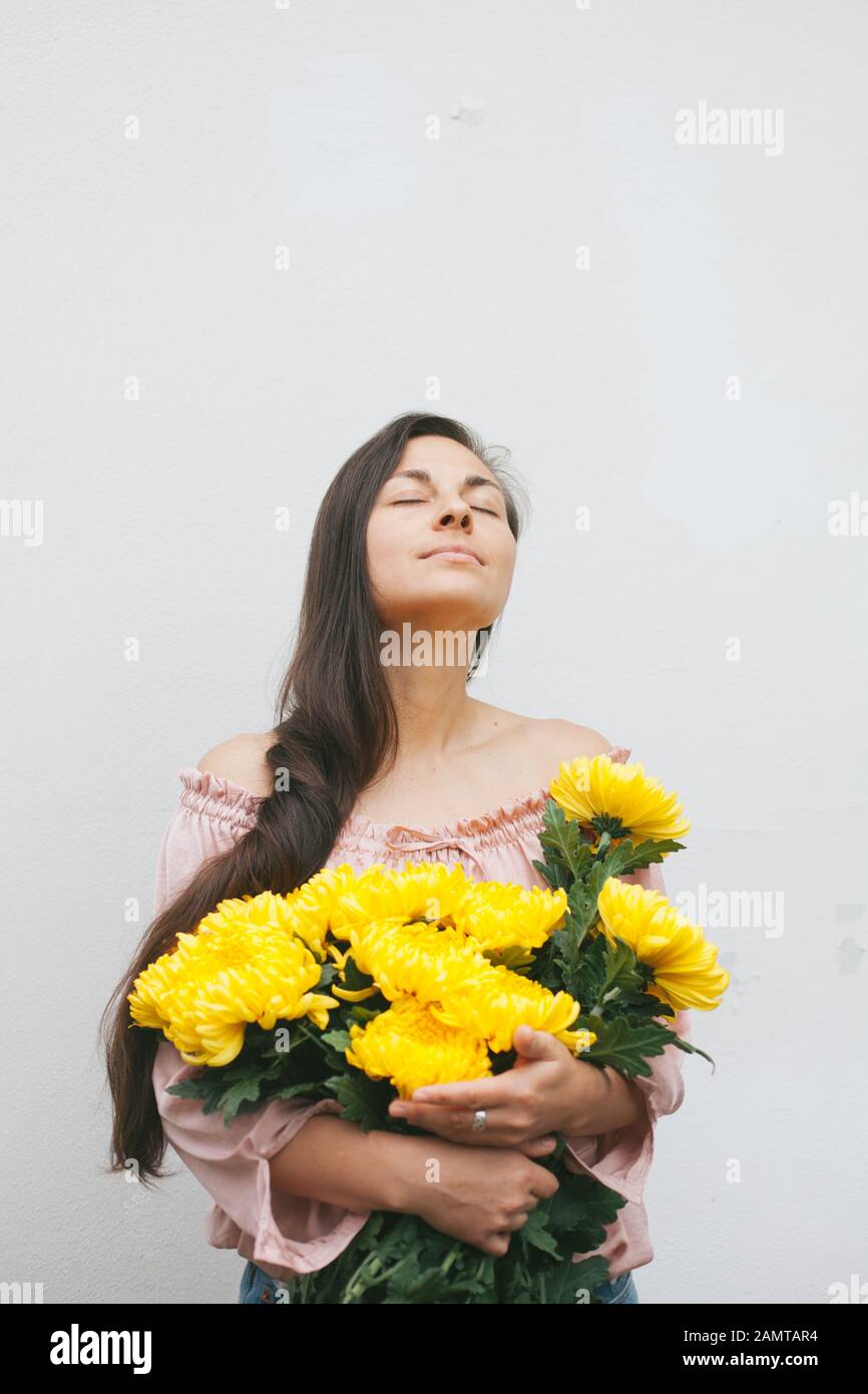 Frau, die einen Blumenstrauß gelber Chrysanthemen hält Stockfoto