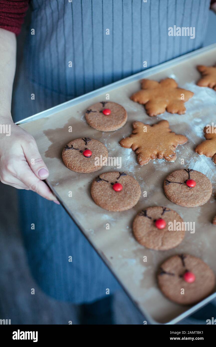 Frau, die ein Backblech mit Lebkuchenplätzchen hält Stockfoto