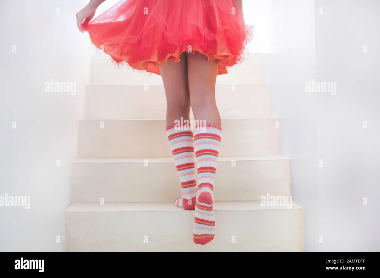 Teenager-Mädchen mit gestreiften Socken, die eine Treppe hinauf gehen Stockfoto