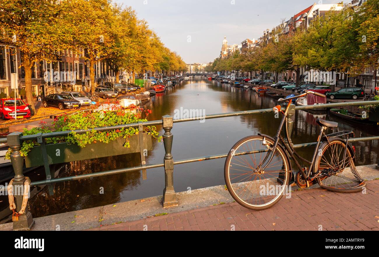 Ein gebrochenes und verlassenes Omafiets-Fahrrad wird auf einer Brücke über den Kaiser-Kanal im Amsterdamer Grachtengürtel Centrum an Geländer verschlossen gelassen. Stockfoto