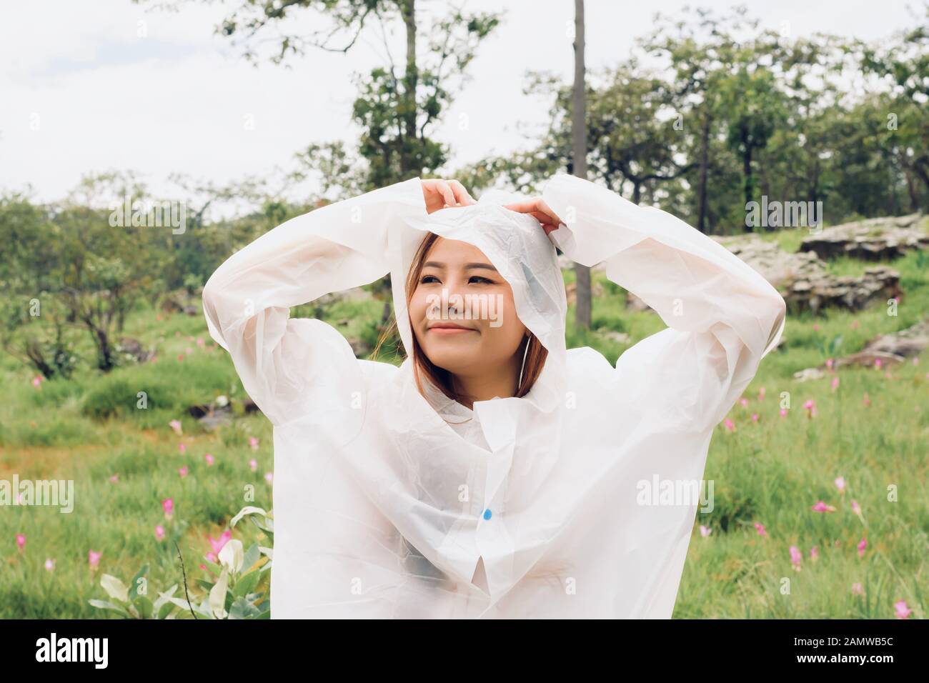 Nahe Frau trägt Regenmantel im Regenwald Stockfoto
