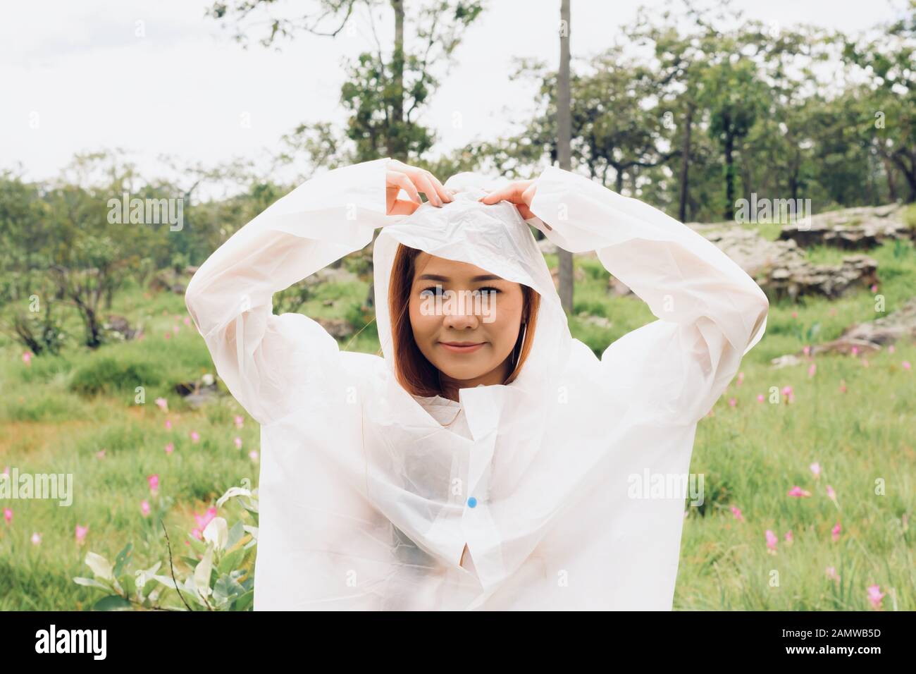 Nahe Frau trägt Regenmantel im Regenwald Stockfoto