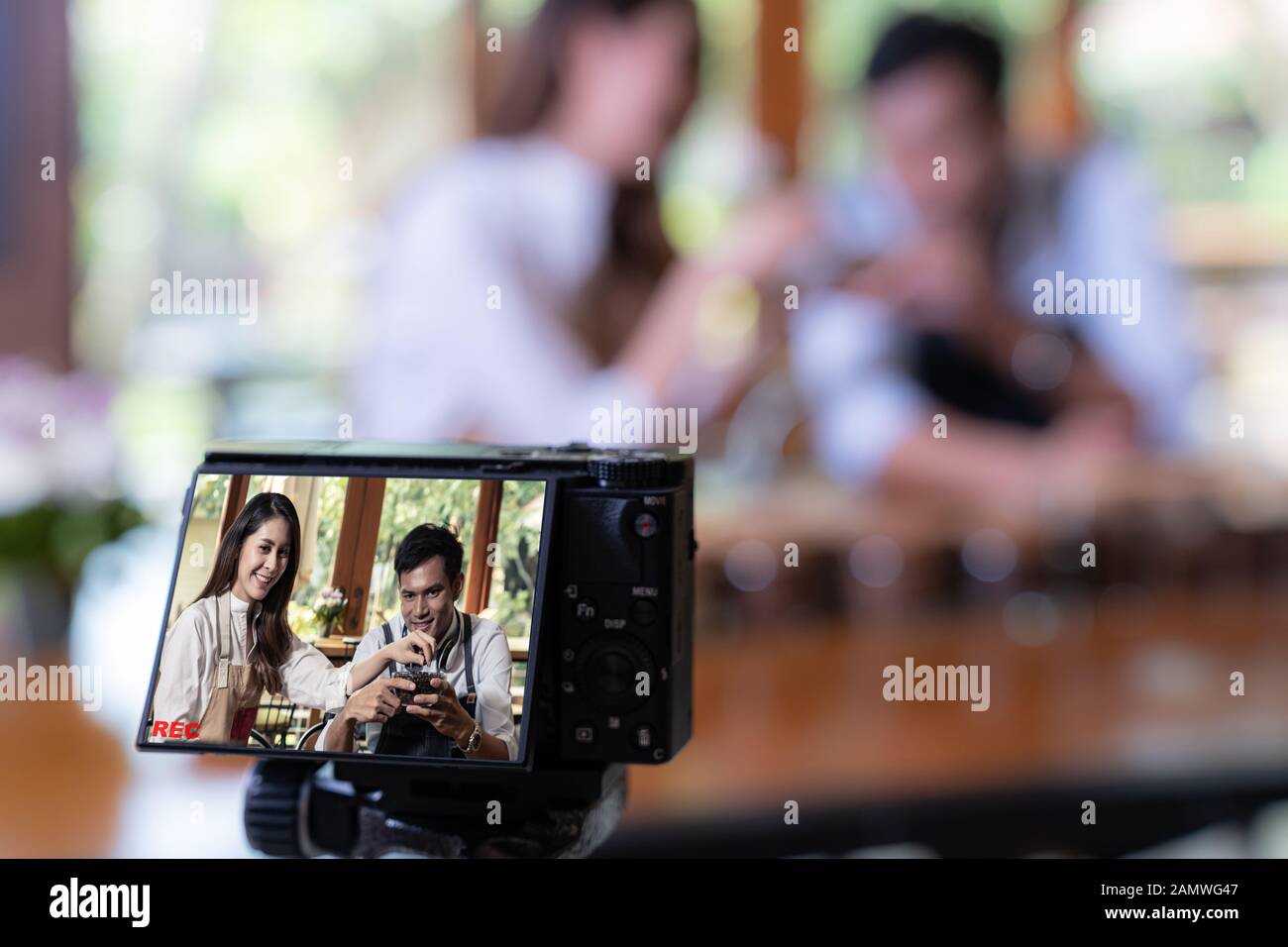 VLOG von jungen erwachsenen Asiatischen Eigentümer Unternehmer bewerten cafe Coffee Shop und Leben in sozialen Medien für Online Marketing mit Kamera im Cafe. Verwendung für Sta Stockfoto