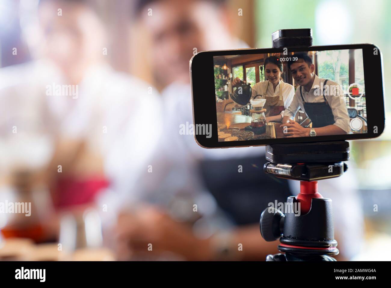 VLOG von jungen erwachsenen Asiatischen Eigentümer Unternehmer bewerten cafe Coffee Shop und Leben in sozialen Medien für Online Marketing mit Smart Phone im Cafe. Mit fo Stockfoto
