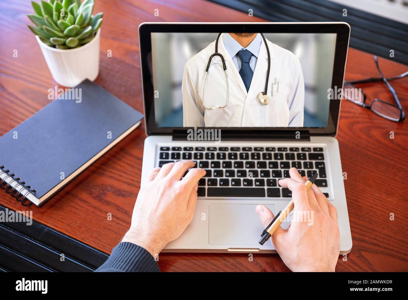 Telemedizin, Online-Gesundheitskonzept. Arzt GP mit einem Stethoskop auf einem Laptop-Bildschirm, Büroschreibtisch Hintergrund Stockfoto