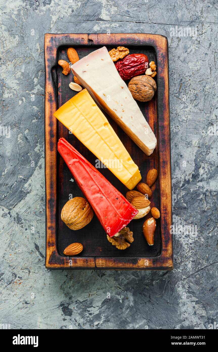 Kochplatten aus Holz mit verschiedenen Käsesorten auf dem Tisch Stockfoto