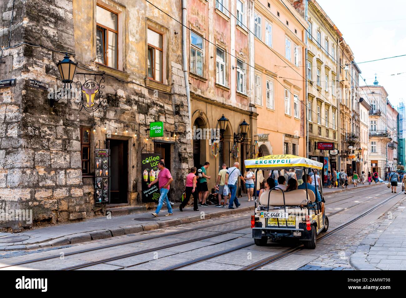 Lwiw, Ukraine - 1. August 2018: Trolleystraßenbahngleise in der historischen ukrainischen polnischen Stadt in der Altstadt mit Reisezugleuten im Auto Stockfoto