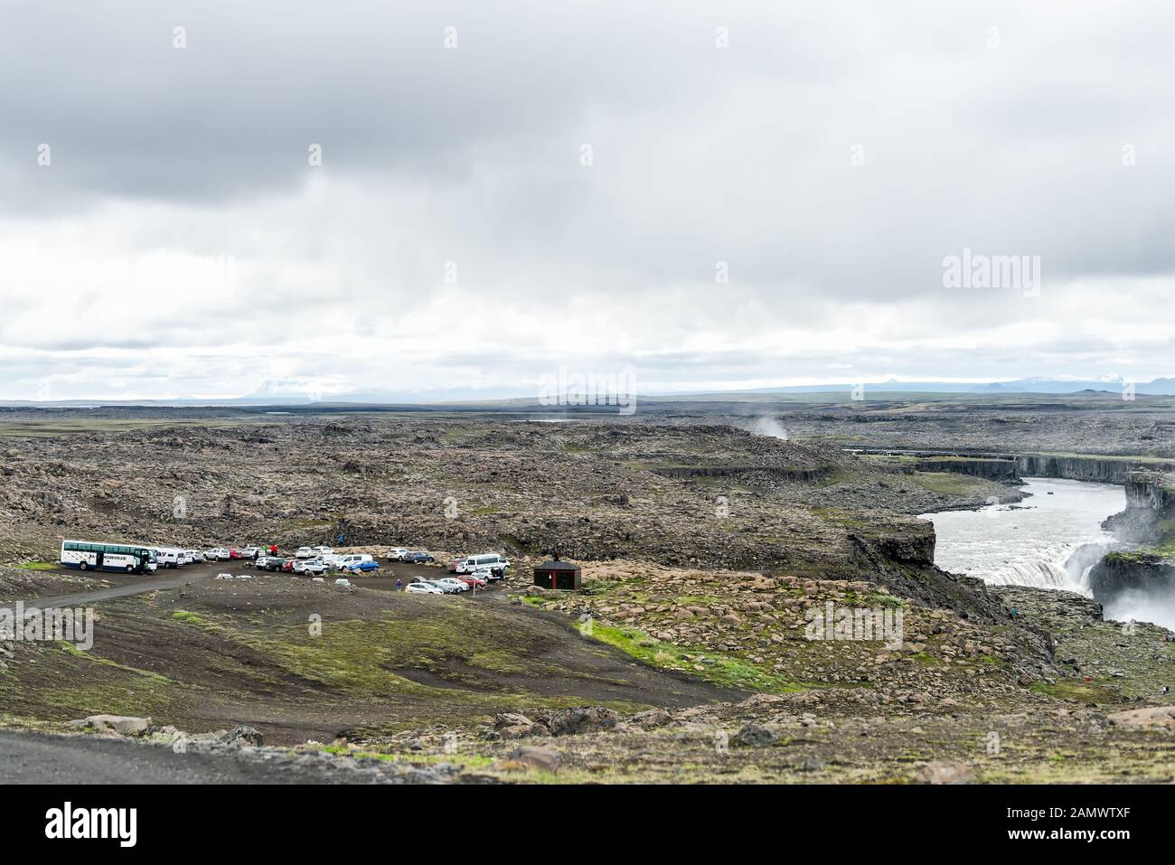 Dettifoss, Island - 16. Juni 2018: Isländischer Wasserfall mit Blick auf den Punkt mit grauer Felswand und Menschen, die mit Parkplätzen wandern Stockfoto