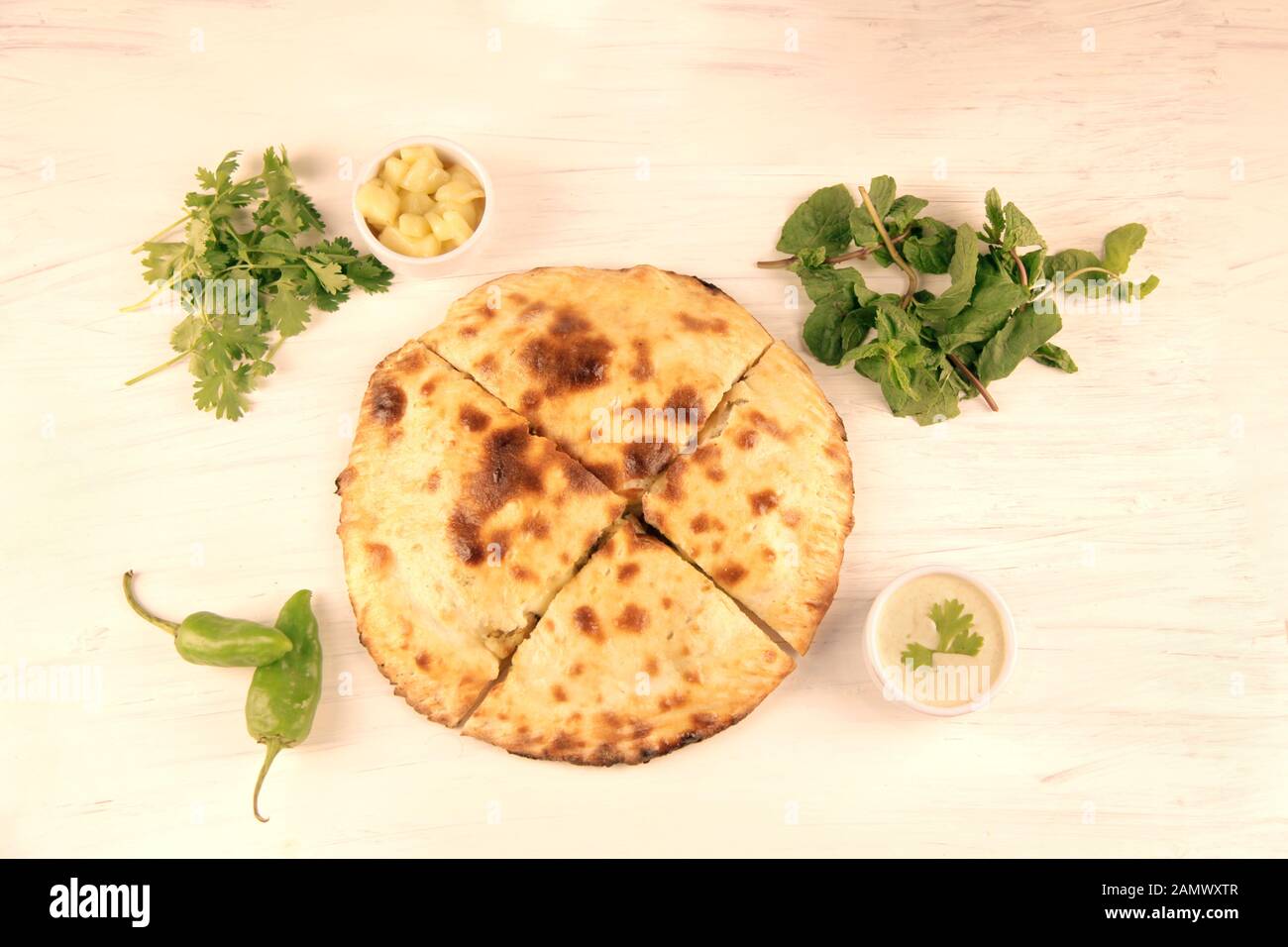Gefüllte naan desi Pizza mit Kräuter Gemüse und Dips. Stockfoto