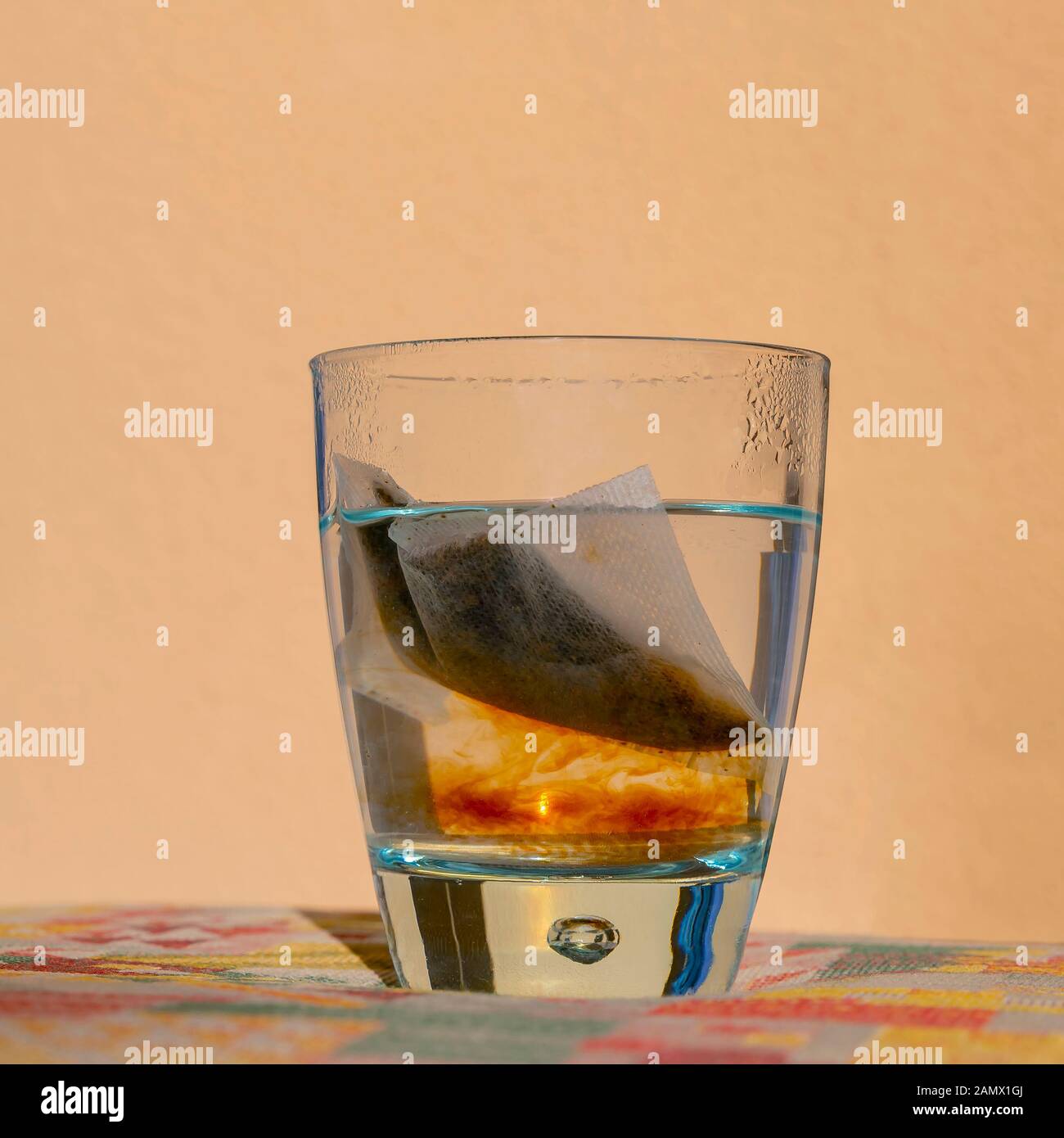 Ein Infusionstee in einem durchsichtigen Glas heißem Wasser gibt seinen wertvollen Inhalt frei Stockfoto