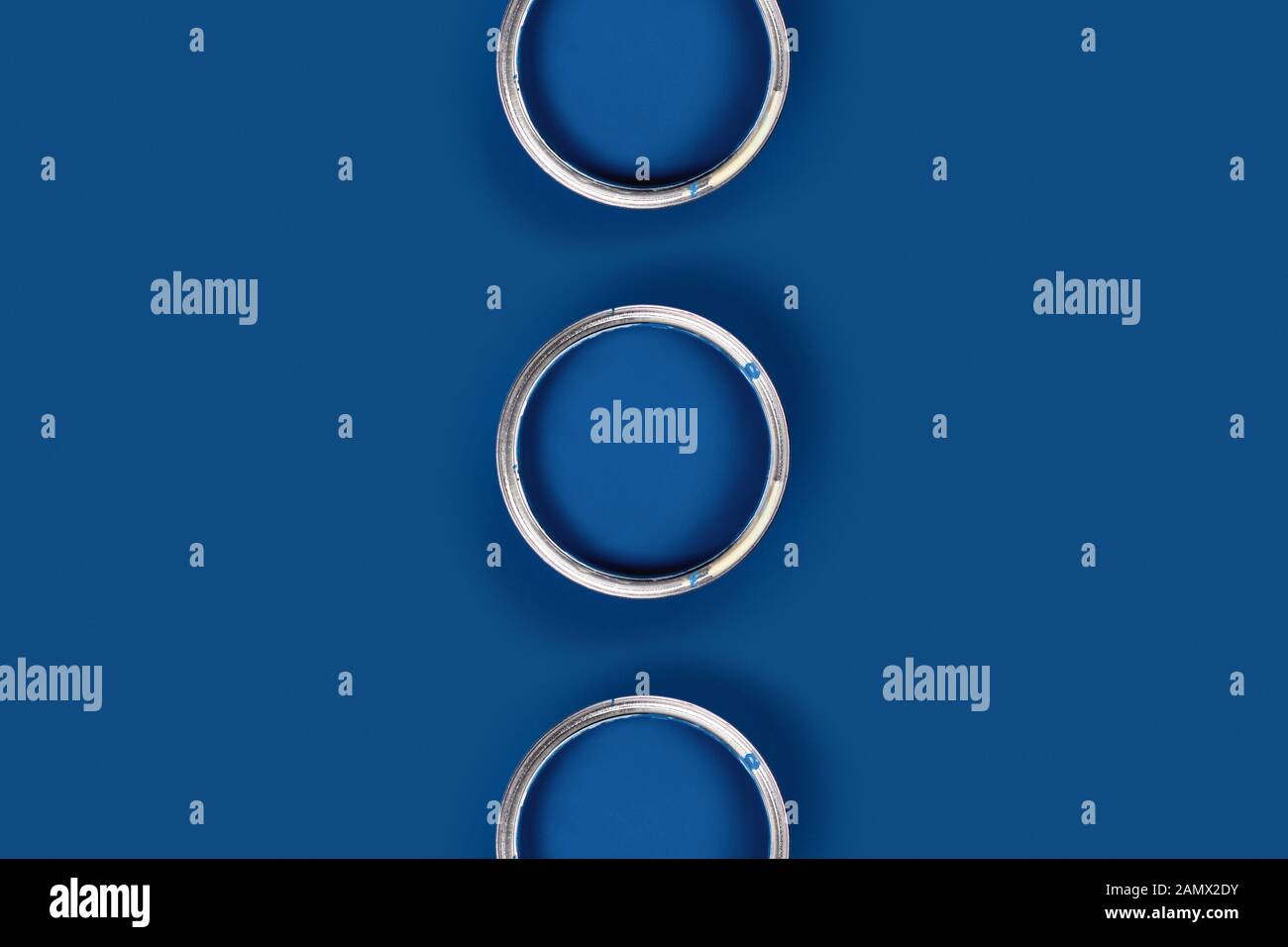 Reparaturbild. Klassischer blauer Hintergrund mit drei blauen Farbdosen. Flaches Layout, Draufsicht, Kopierbereich. Stockfoto