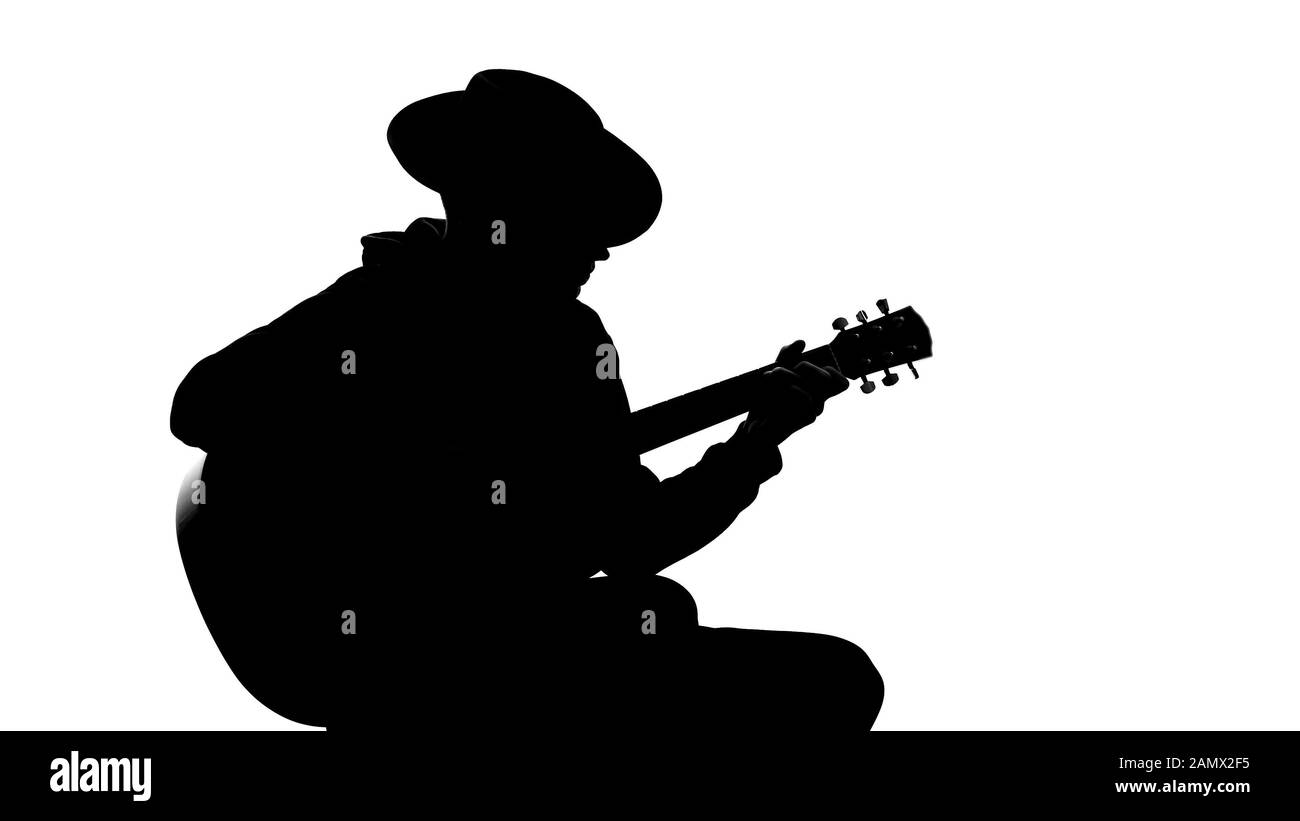 Silhouette junger Männer in Hut Gitarre auf Party spielen, cooles Hobby, Freizeit Stockfoto