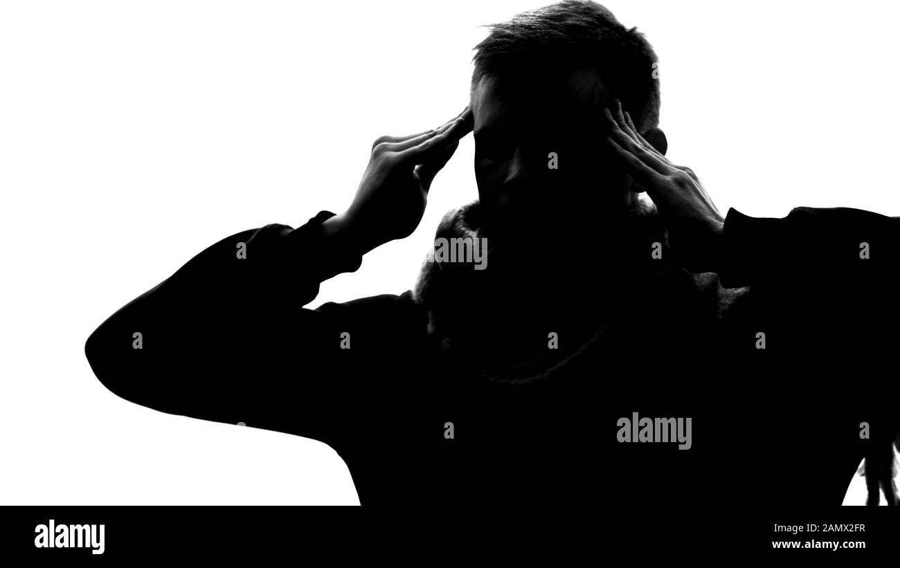 Silhouette des müden jungen Mannes, der chronische Kopfschmerzen, reibende Schlägel und Fieber spürt Stockfoto