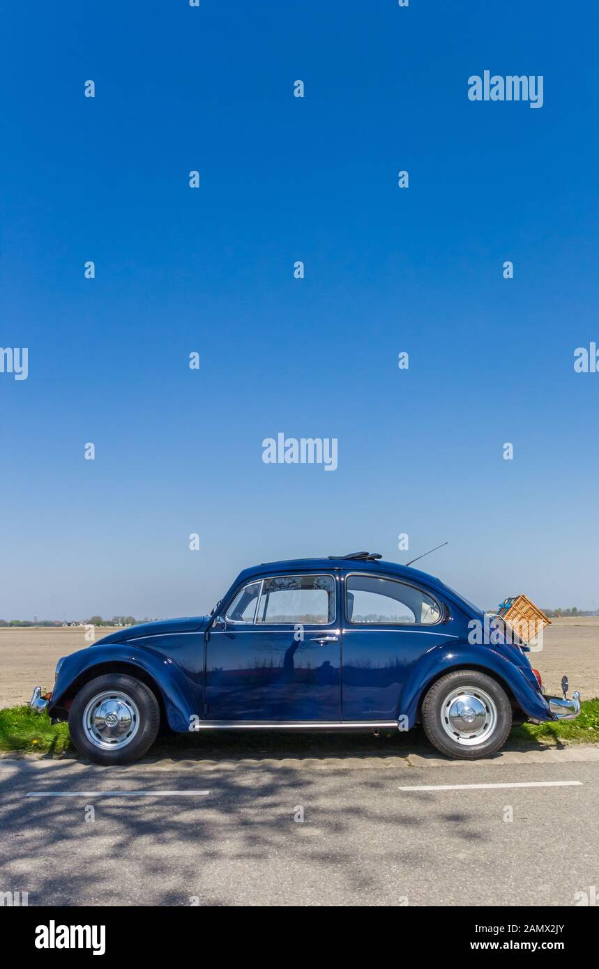 Klassischer blauer Volkswagen-Käfer auf einer Landstraße in Den Niederlanden Stockfoto