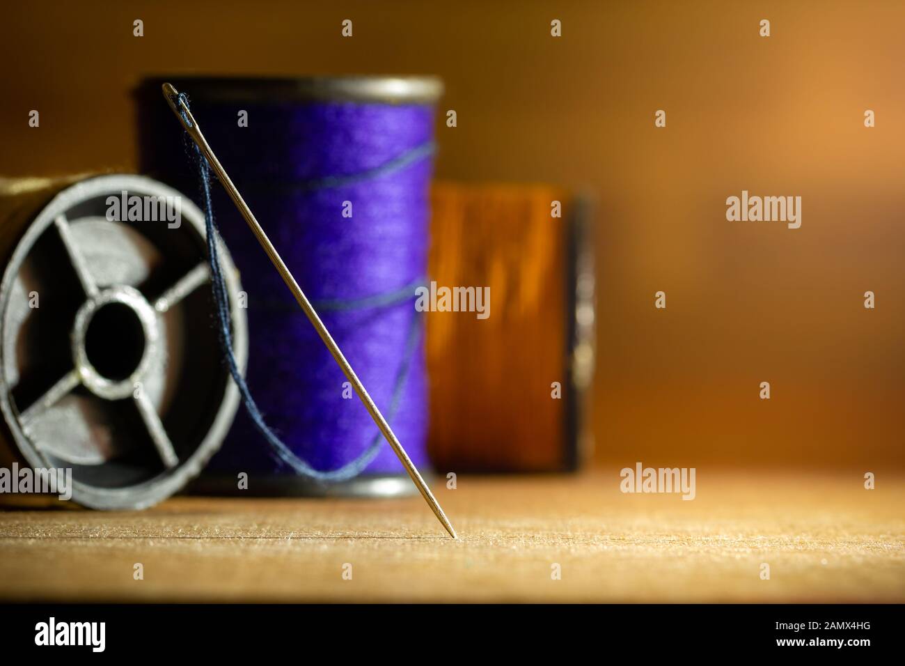 Nadel und Threads auf Holztisch. Closeup kopieren und Platz für Text. Konzept der maßgeschneiderten oder Designer. Stockfoto
