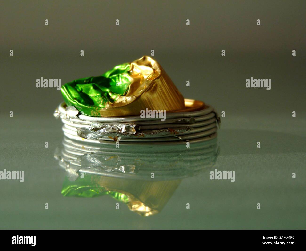 Abgeflachte gebrauchte Aluminium-Kaffeekapseln auf glänzender Glasoberfläche. Recycling-Konzept. Moderner Lebensstil. Umweltschutz. Ökologischer Fußabdruck Stockfoto