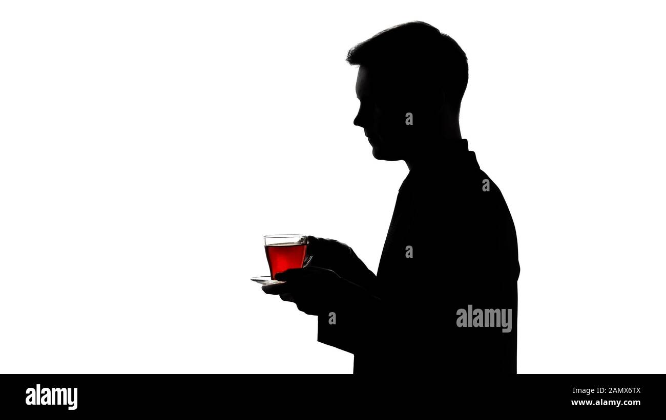 Dunkle Silhouette des Mannes, der Glas Tee trinkt, Erholung, pH-Balance wiederherstellen Stockfoto