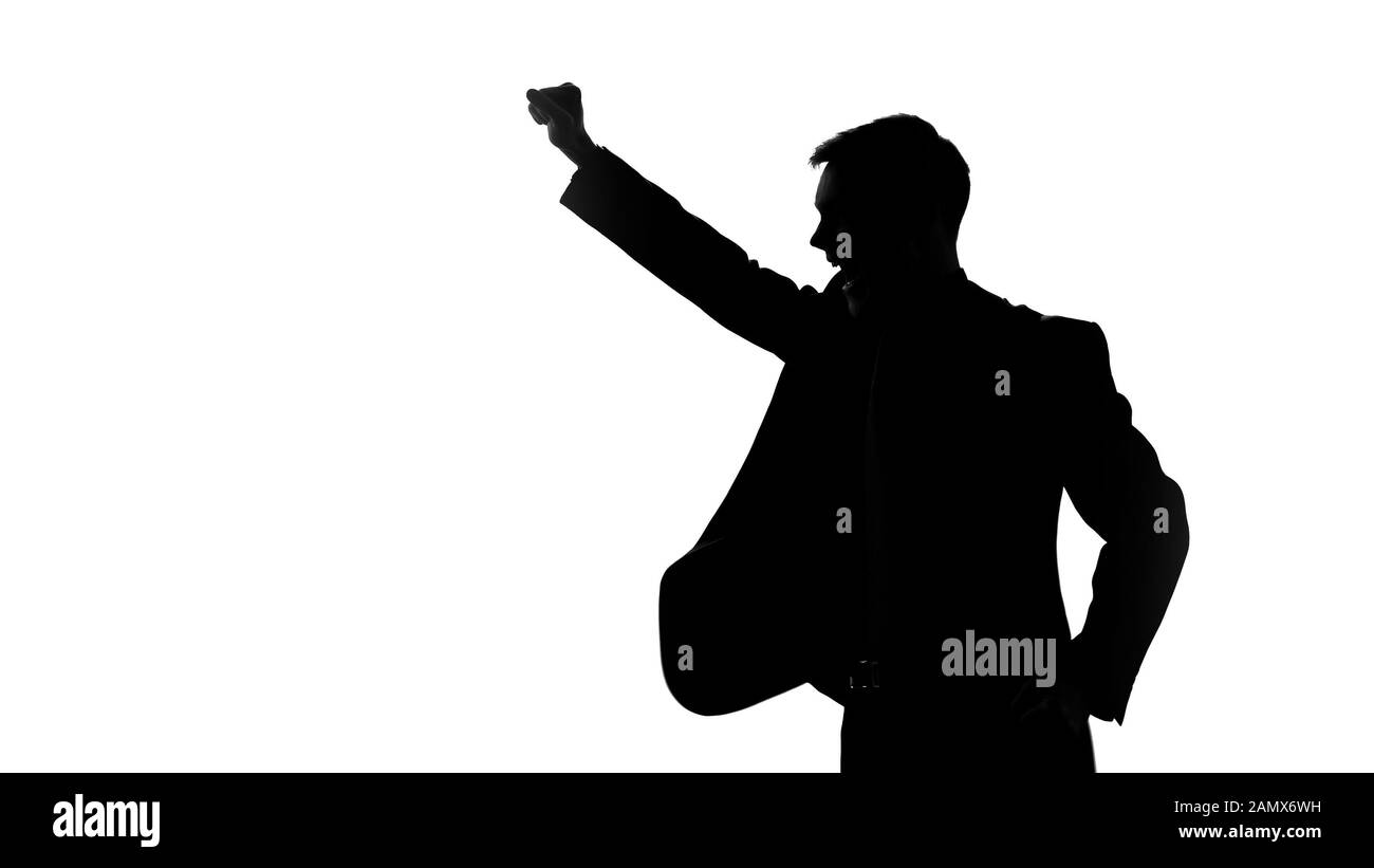 Die Silhouette des Mannes hebt die Fäuste auf, feiert den Sieg, ein gutes Schnäppchen, Seitenansicht Stockfoto