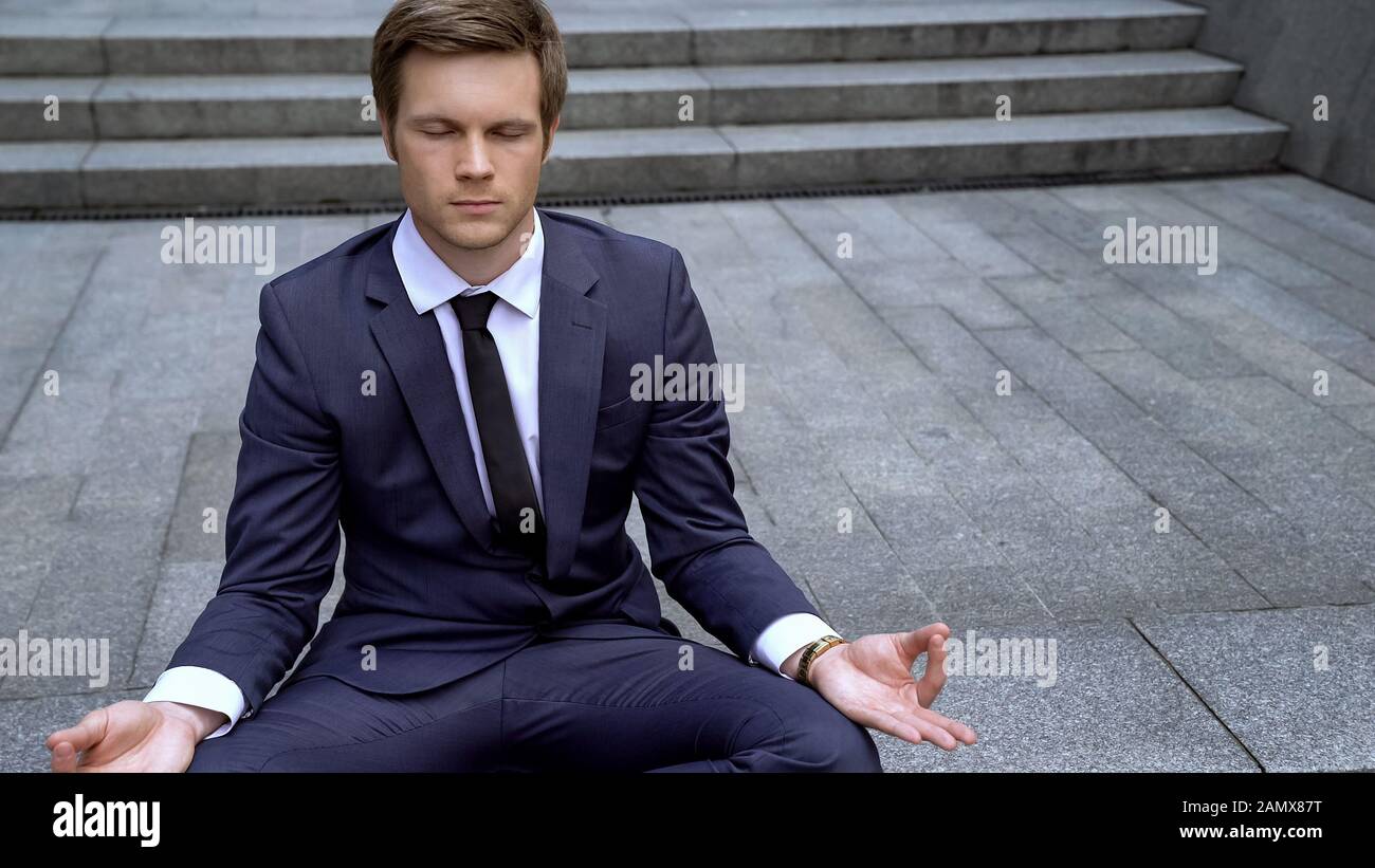 Junger gutaussehender Geschäftsmann in lotus-position auf Treppen, Selbstkontrolle in der Großstadt Stockfoto