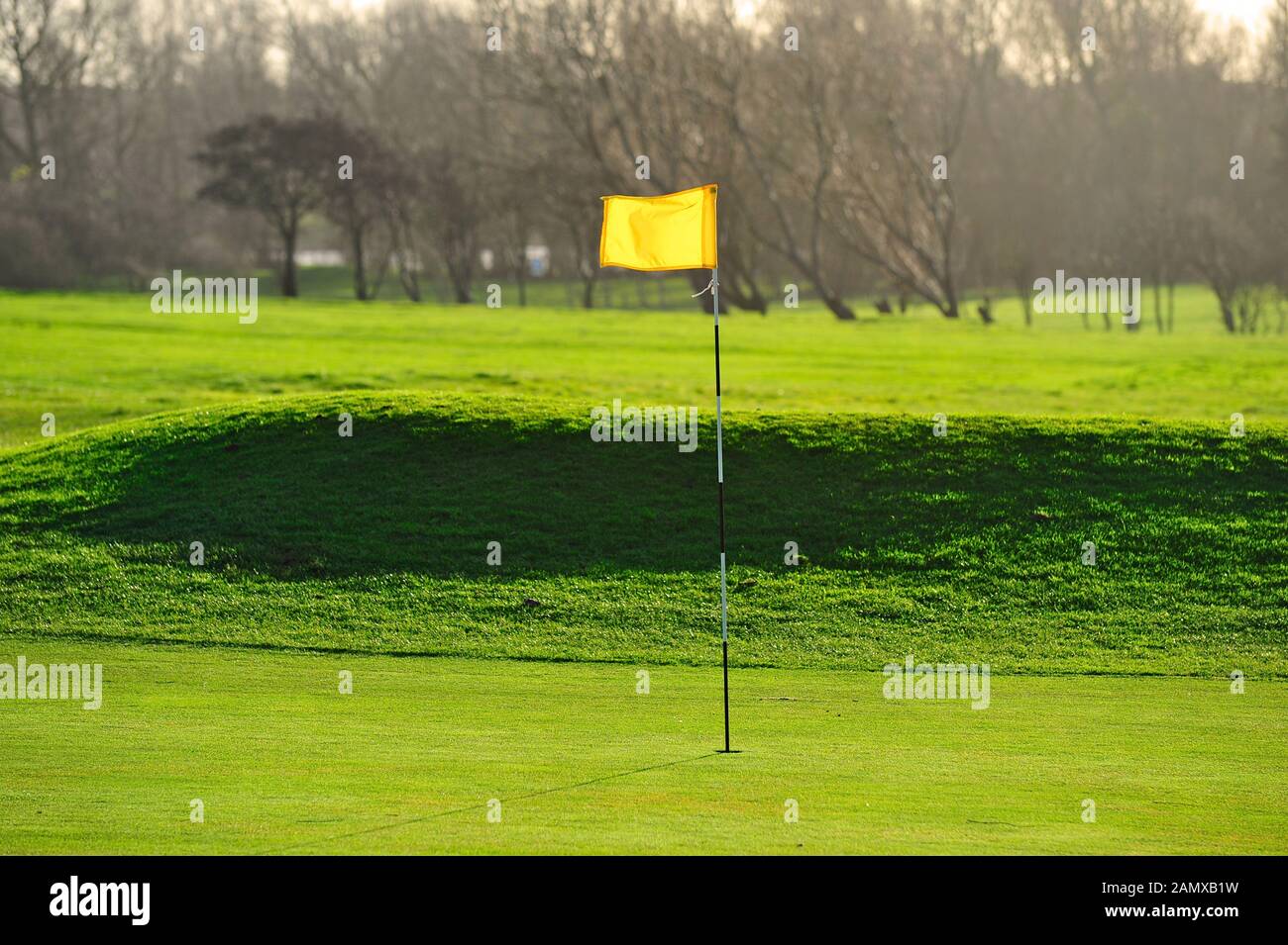 Gelbe Fahne, die im Wind an einem sonnigen Tag im Winter auf dem Golfplatz weht Stockfoto