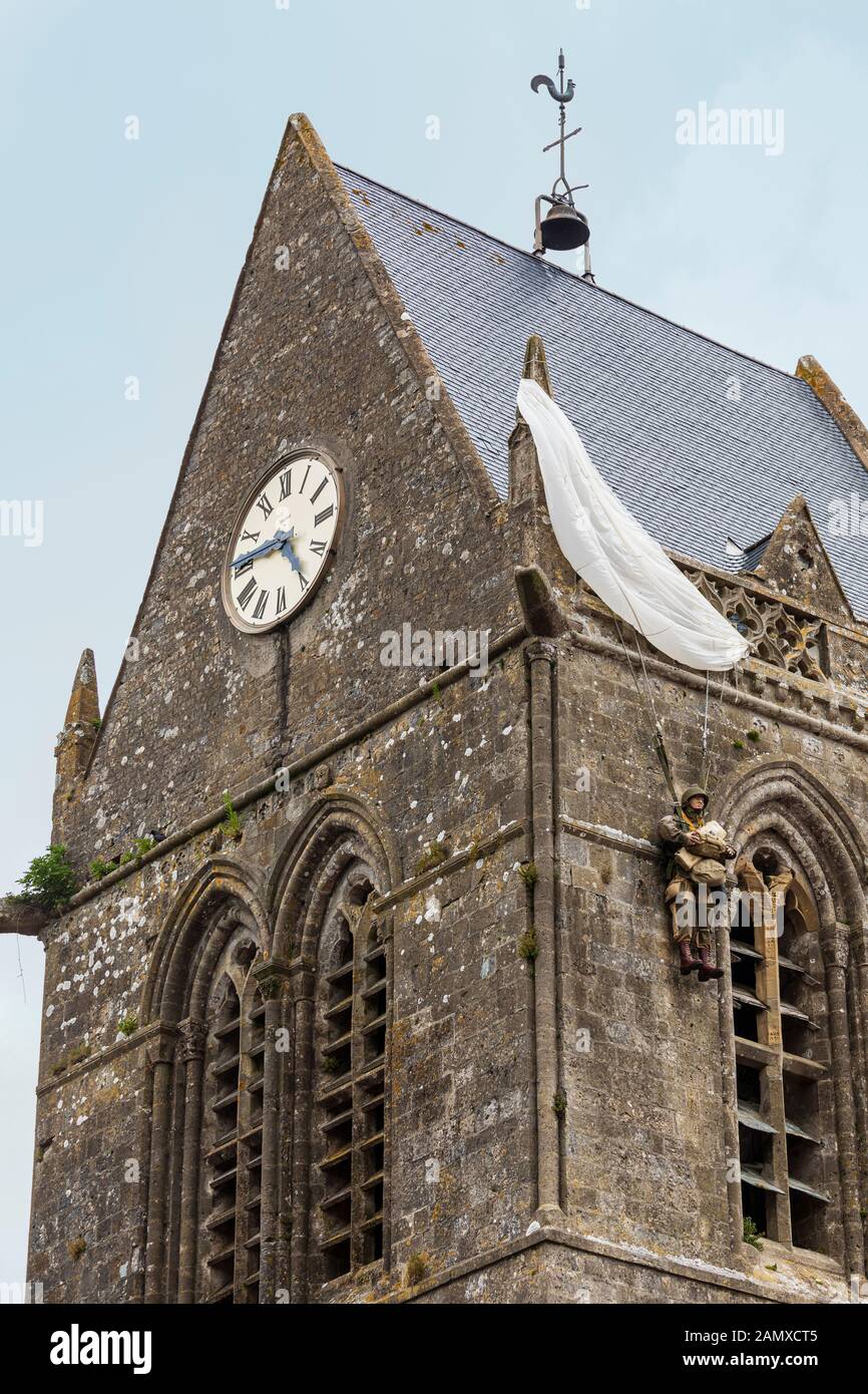 Attrappe des Fallschirmjägers John Steele, der während der alliierten Invasion im zweiten Weltkrieg auf der Spitze der Kirche von Sainte-Mère-Église in der Normandie festsaß Stockfoto