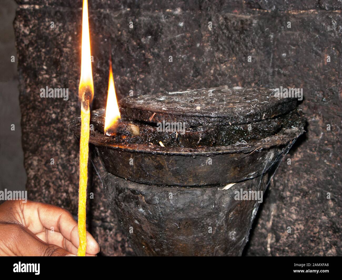 Der Mönch beleuchtet eine traditionelle Öllampe im Kloster Kebran Gabriel, Kebran Gabriel Island, Lake Tana. Äthiopien. Stockfoto