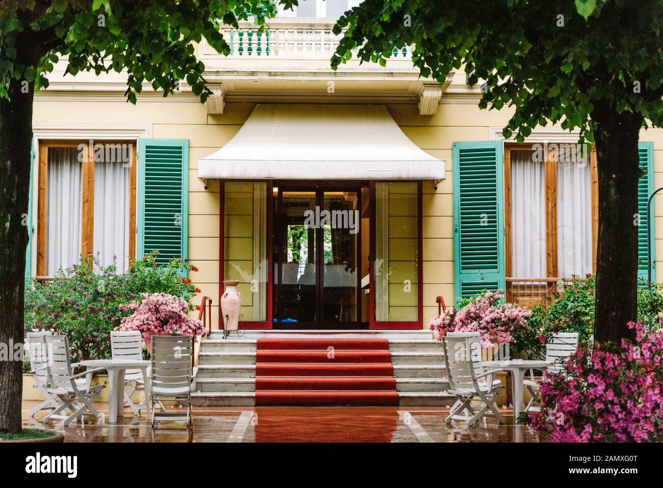 Eingang des Italienischen Haus oder Hotel mit schön gemacht, Veranda organisiert. Rote Spur auf den Stufen der Treppe. Hintergrund für die Reise oder Stockfoto
