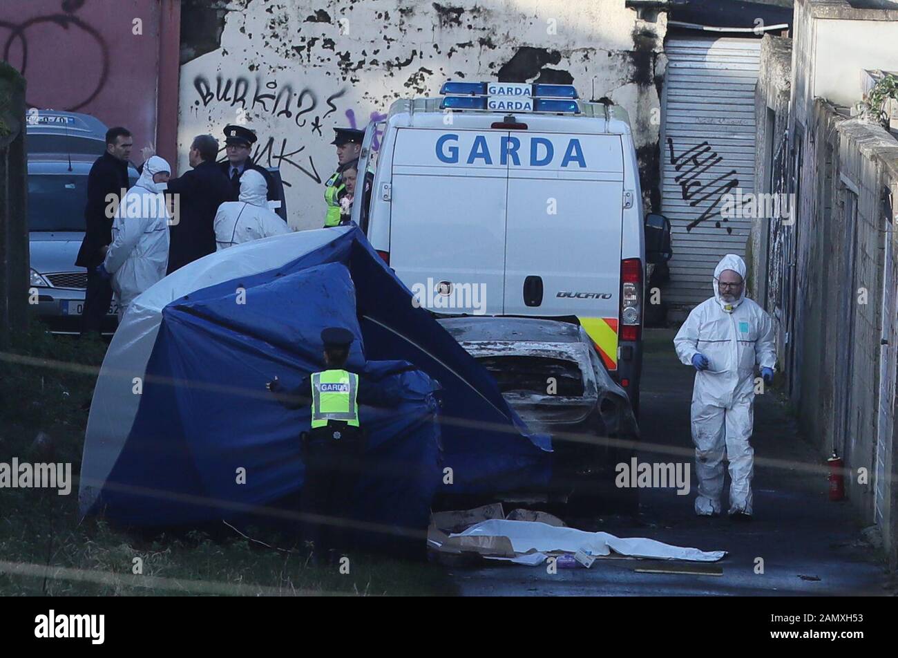 Forensics Offiziere und Garda am Tatort auf Trinity Terrace im Drumcondra-Gebiet von Dublin, wo menschliche Überreste, die vermutlich mit dem Verschwinden eines 17-jährigen Jungen aus Co Louth in Verbindung stehen, in einem ausgebrannten Auto gefunden wurden. Gardai erwartet DNA-Ergebnisse, um zu sehen, ob menschliche Gliedmaßen, die am Montag in Coolock gefunden wurden, auch zum vermissten Teenager gehören. Stockfoto