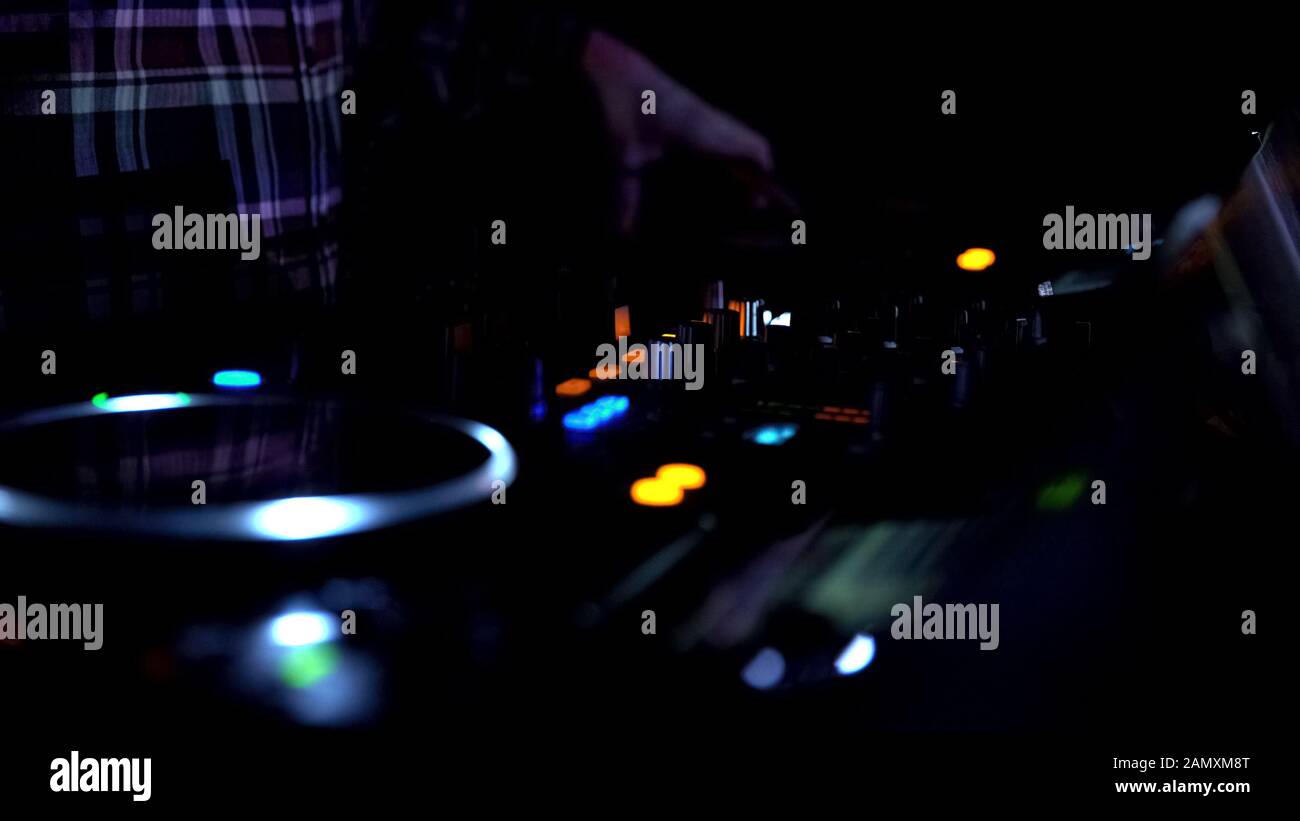 Nahaufnahme von Diskjockey Hände, die Musikplatten mischen, Nachtklub-Atmosphäre Stockfoto