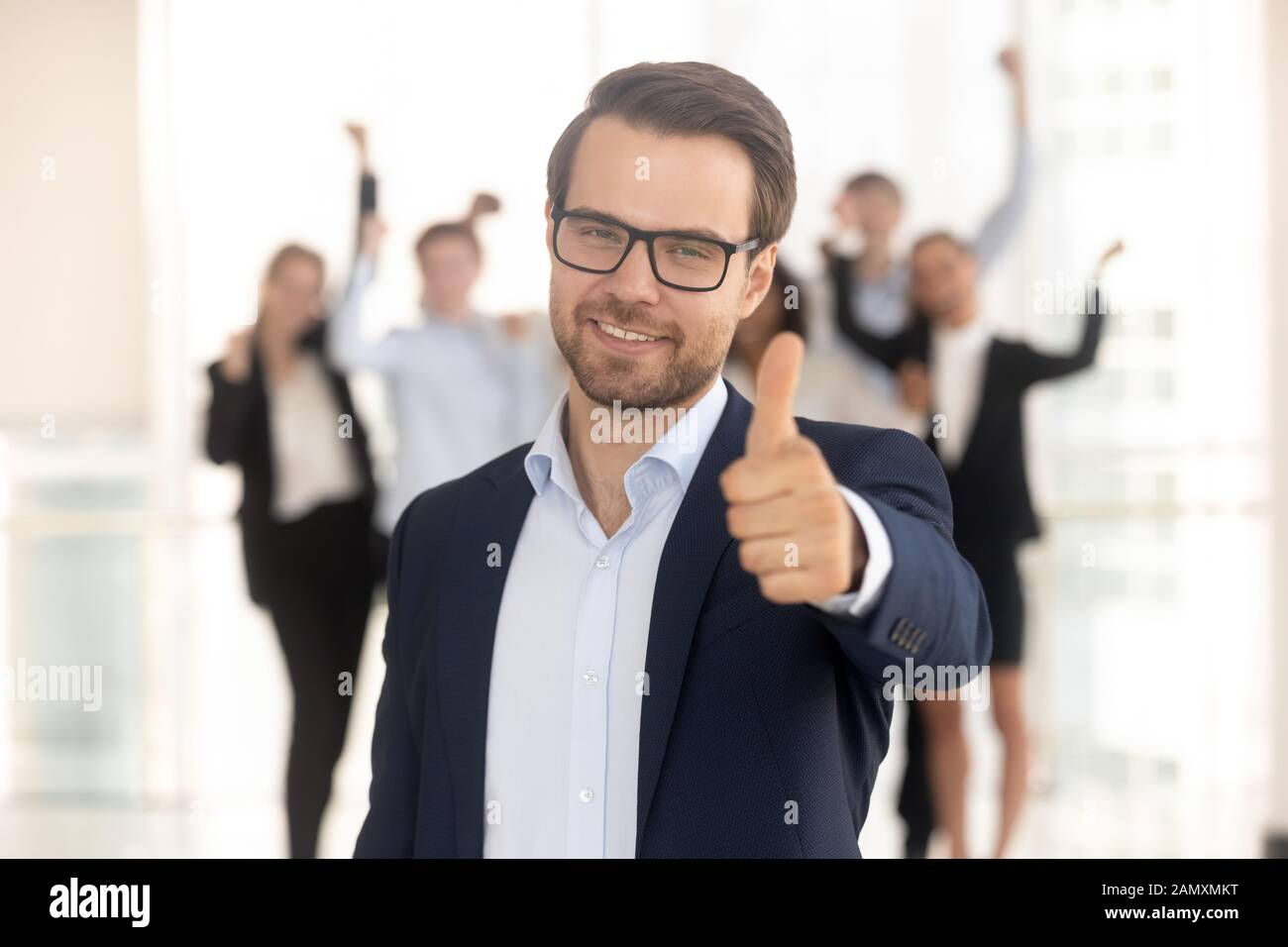 Porträt eines lächelnden Geschäftsmannes zeigt Daumen nach oben und empfiehlt Service Stockfoto