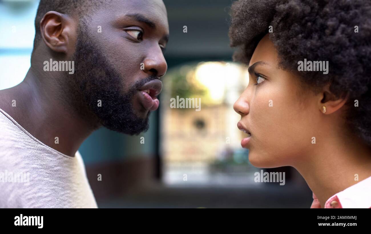 Junge afro-amerikanische Paare streiten im Freien, Missverständnisse, eifersüchtiger Ehepartner Stockfoto