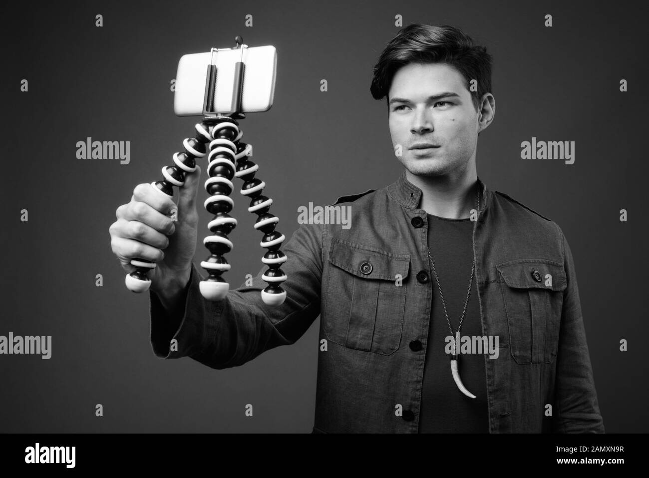 Studio shot Junger stattlicher Mann vlogging mit Telefon Stockfoto