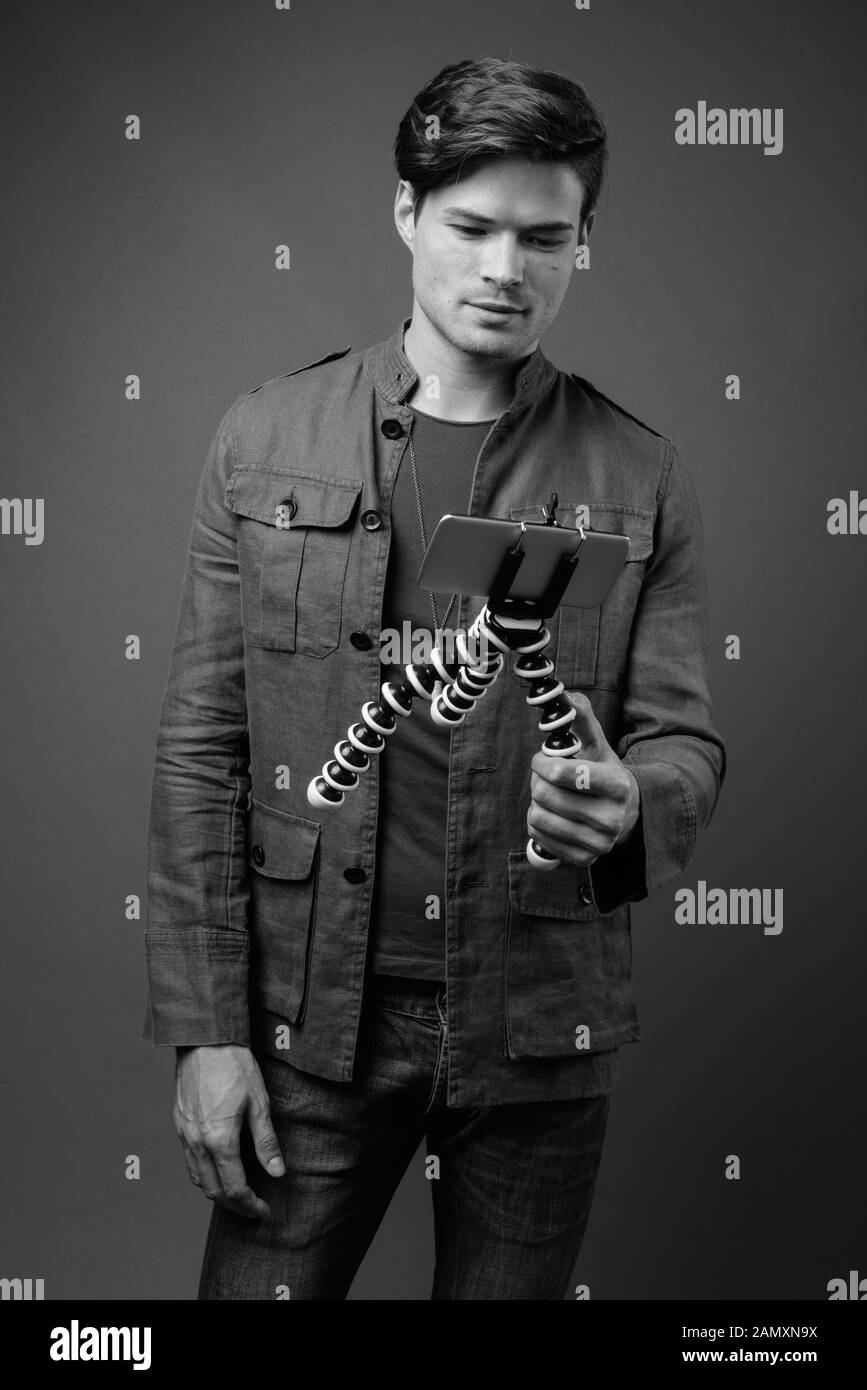 Studio shot Junger stattlicher Mann vlogging mit Telefon Stockfoto