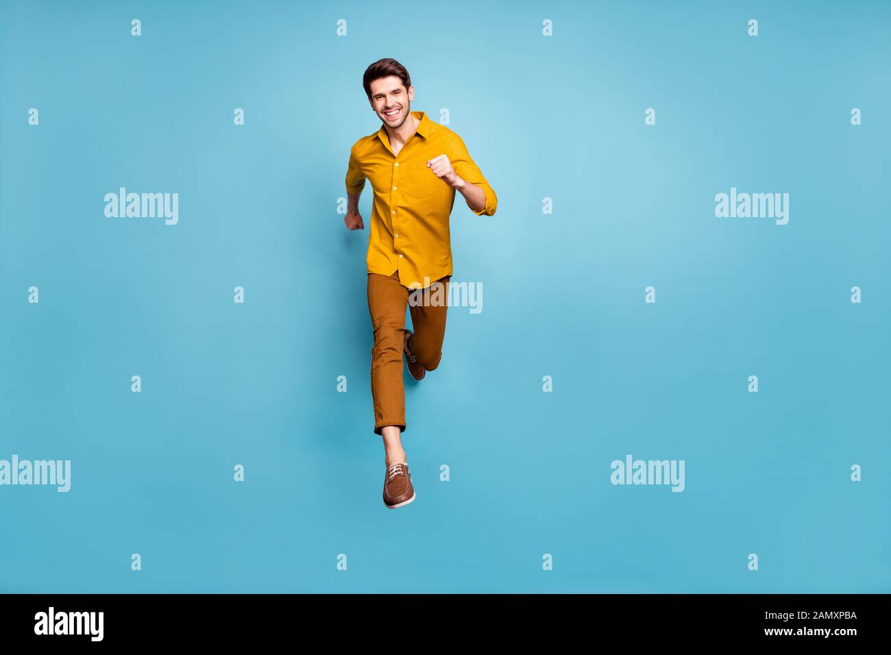 Ich bin Sieger. Volle Länge Foto der lustige Kerl aufgeregt Springen hohe Geschwindigkeit fast Finish Line tragen gelb Shirt Hose isoliert Blau Stockfoto