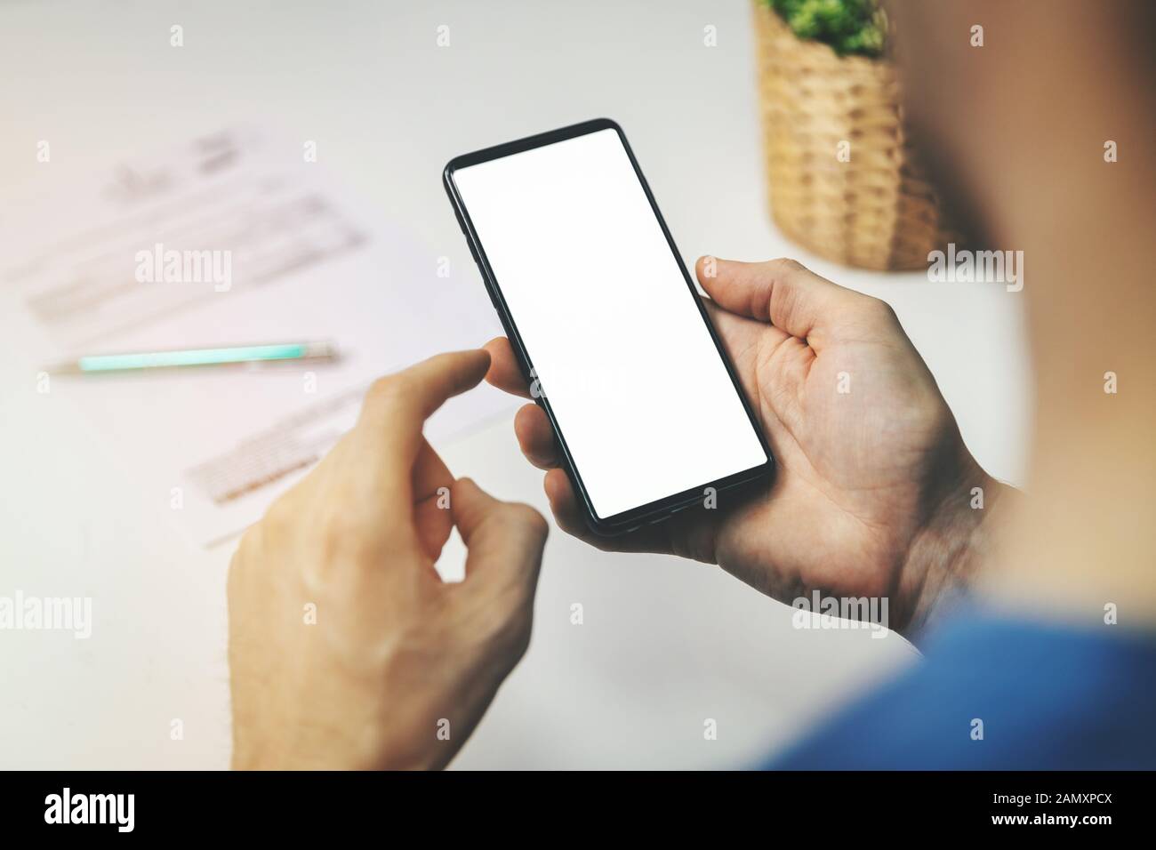 Mann, der Smartphone für Finanztransaktionen verwendet. Telefon mit leerem Bildschirm in der Hand halten Stockfoto