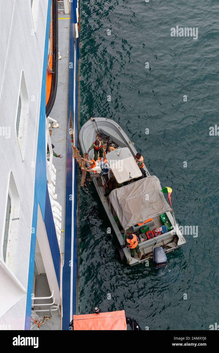 Sicherheitsberater, die im November von einem kleinen Küstenschiff Des Anti-Piraterie-Handwerks in der Bucht von Conakry in ein Schiff von Pilot Ladder einsteigen. Stockfoto