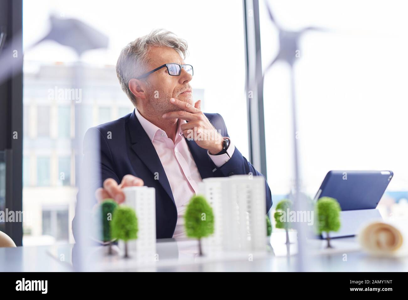 Ein geschäftiger Geschäftsmann, der über neue Lösungen nachdenkt Stockfoto