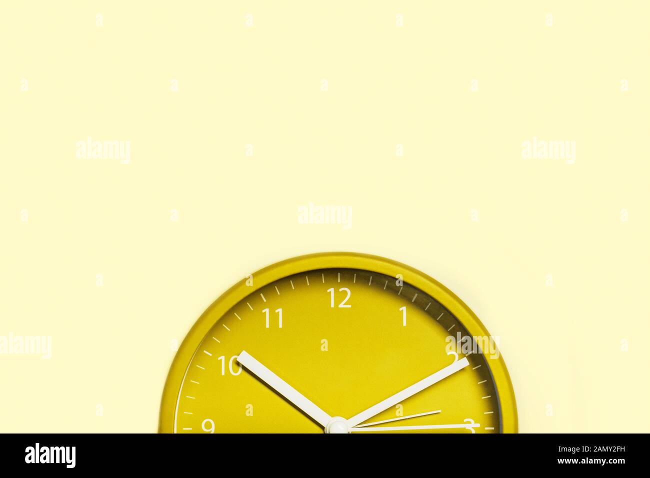 Teilansicht der orangefarbenen Uhr auf gelbem Hintergrund mit Kopierbereich. Stockfoto