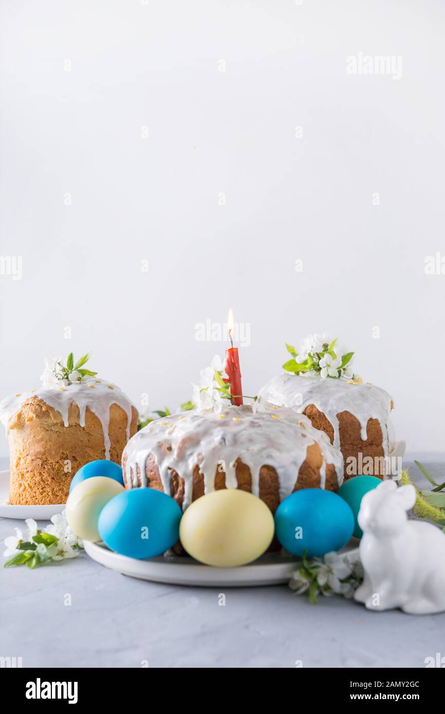 Osterkuchen und bunte traditionelle Eier, Frühlingsblumen in Vase. Nahaufnahme. Vertikales Format. Stockfoto