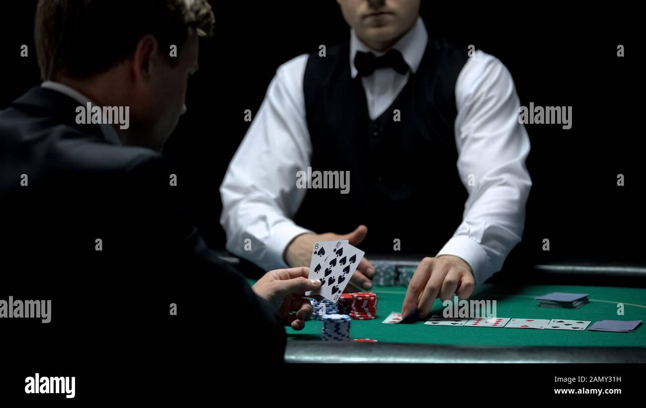 Verärgerter Casino-Client mit schlechter Kartenkombination im Poker, schwache Hand-House-Gewinne Stockfoto