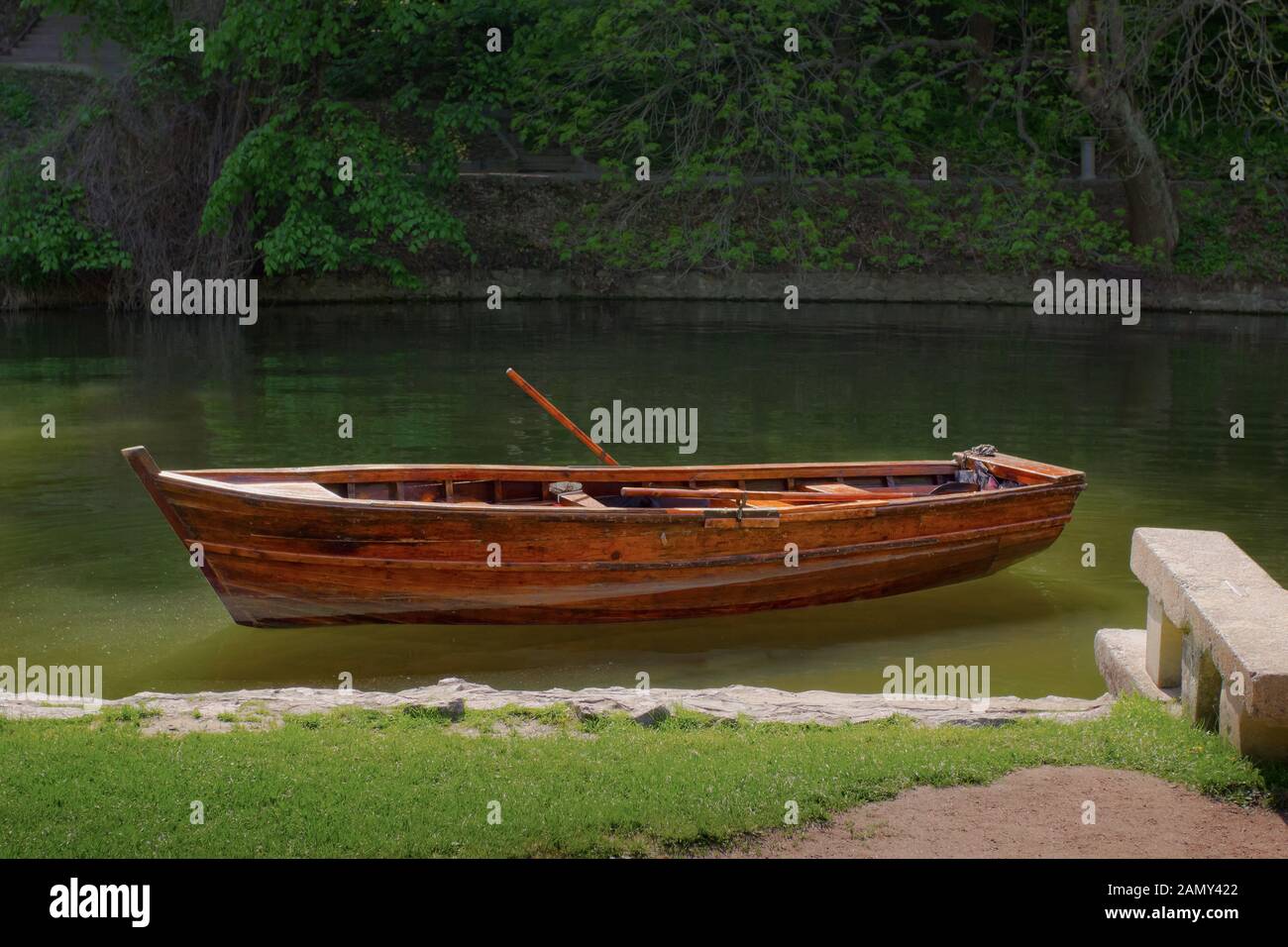 Holzboot in der Nähe des Flussufers im Park, Einsamkeit und Ruhe, Entspannung Stockfoto