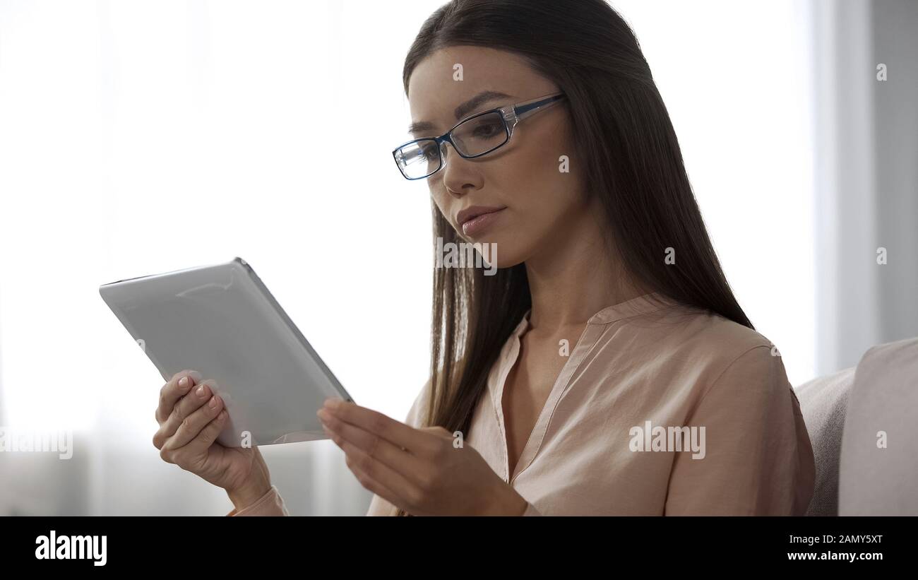 Konzentrierte Geschäftsfrau überprüft Diagramme auf Tablets und überprüft Unternehmenskennzahlen Stockfoto