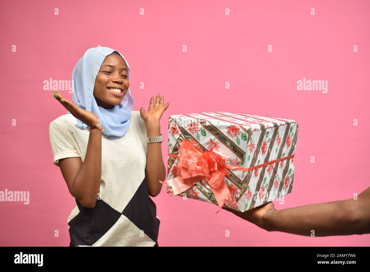 Die hübsche afrikanische Dame fühlt sich aufgeregt, als sie ein Geschenk von jemandem erhielt Stockfoto