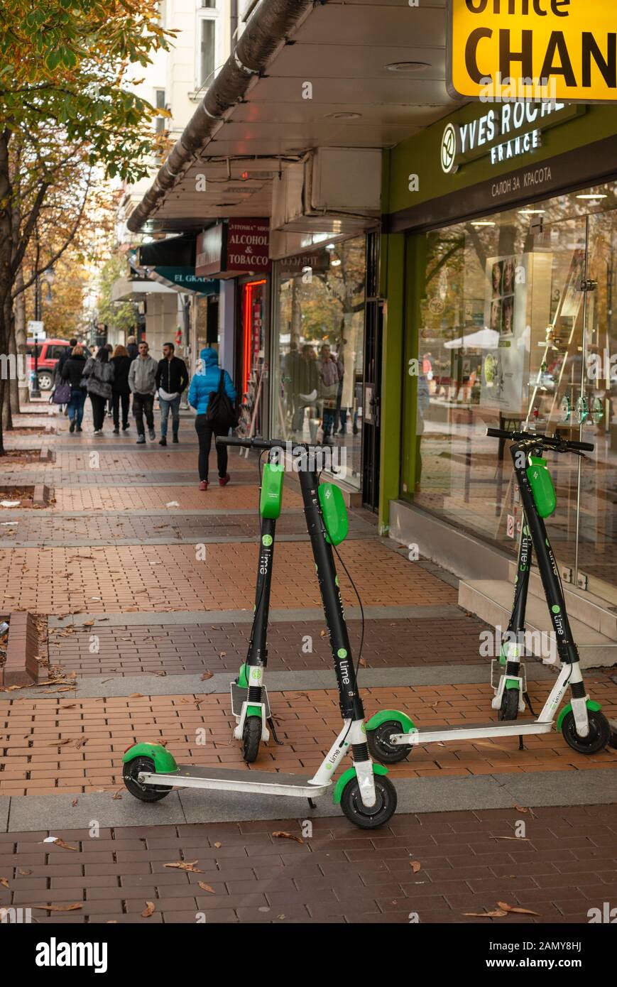 Mehrere Lime-Elektroroller oder E-Roller wurden unordentlich auf dem Bürgersteig in Sofia, Bulgarien, Osteuropa und der EU verstreut zurückgelassen Stockfoto