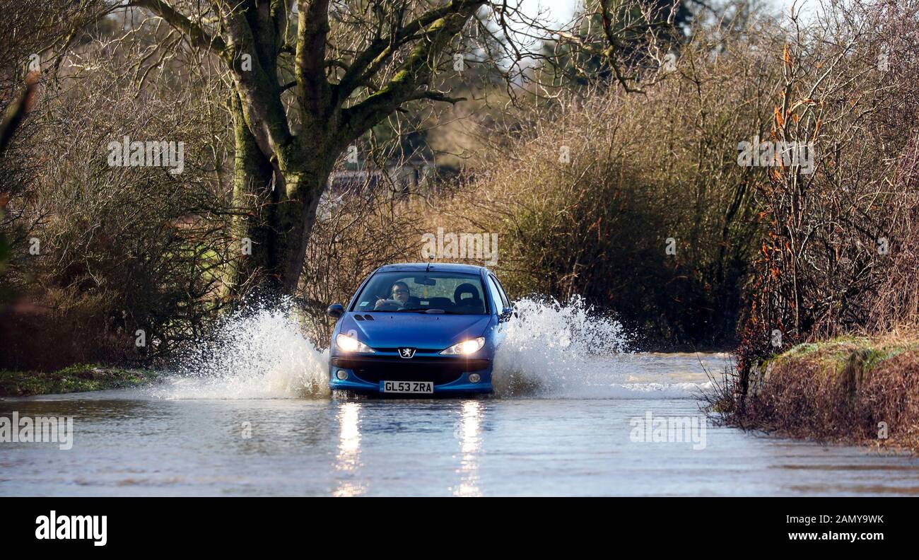 Fahrzeuge verhandeln über die überflutete B4069-Straße bei Christian Malford in Wiltshire, nachdem der Fluss Avon seine Ufer platzte. Stockfoto