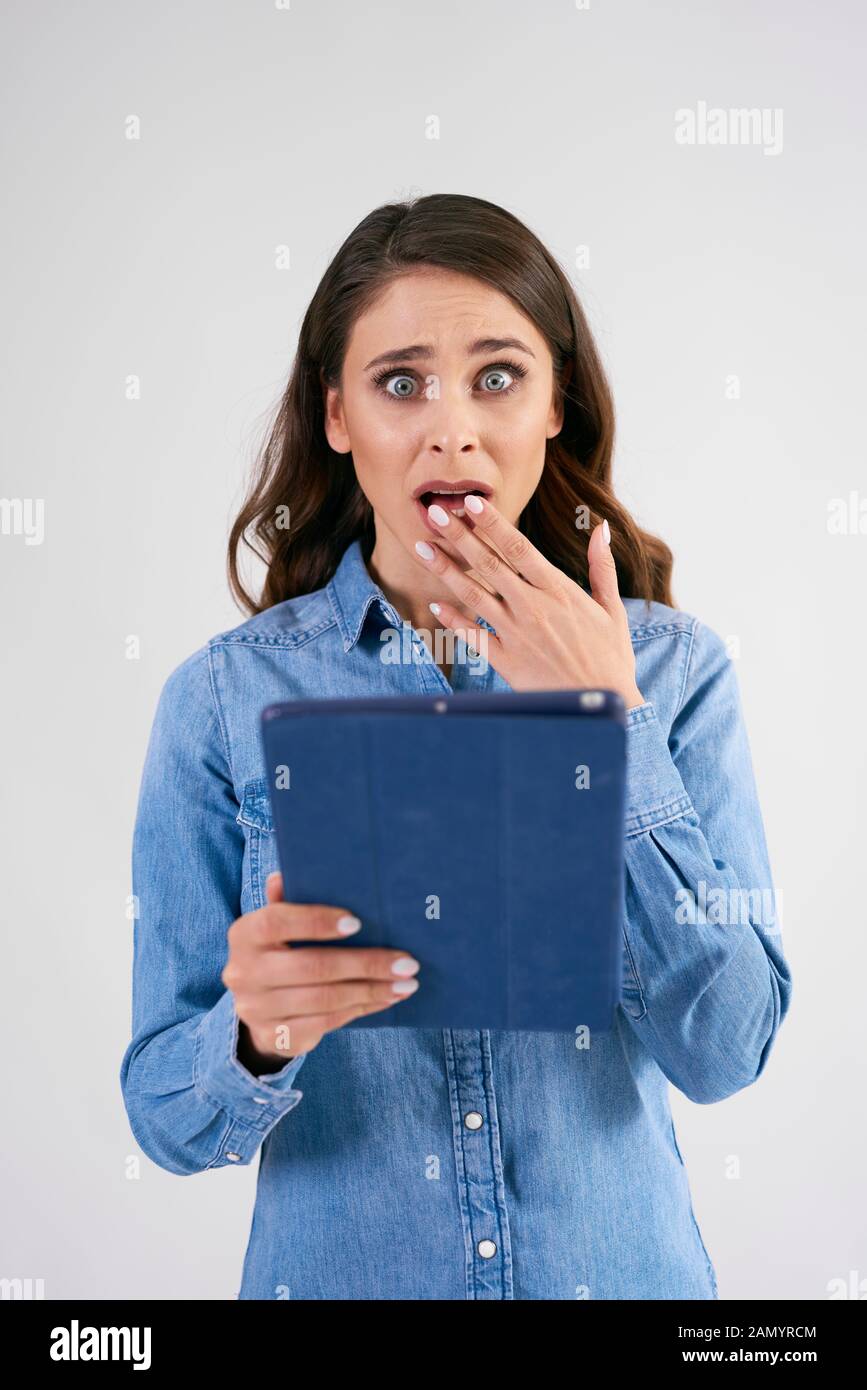 Schockierte Frau mit Tablet im Studio erschossen Stockfoto